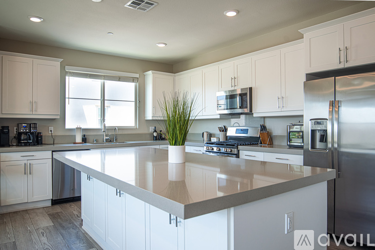 A kitchen with white cabinets and a large island.