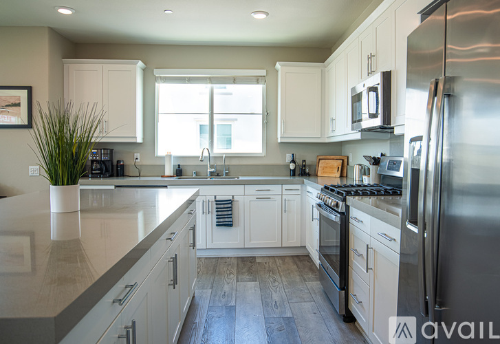 A modern kitchen with white cabinets and stainless steel appliances.