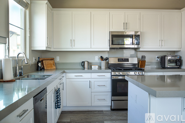 A kitchen with white cabinets and stainless steel appliances.