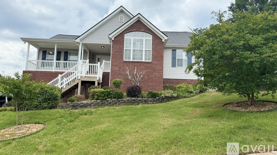A house with a red brick chimney and a white porch.