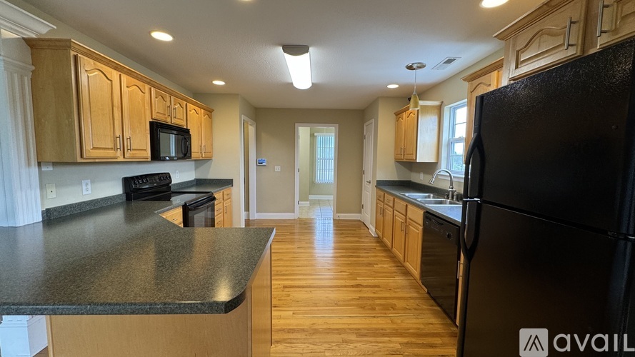 A kitchen with wooden cabinets and black appliances.
