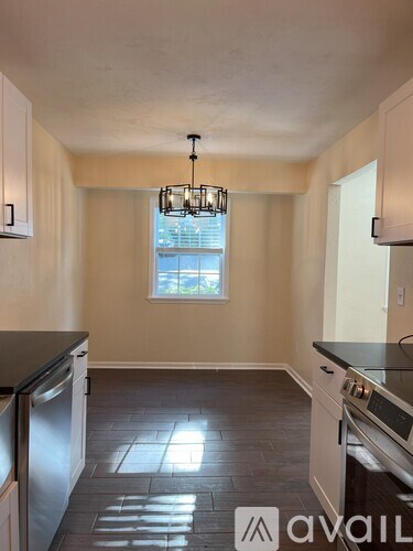 A kitchen with a window and a chandelier.