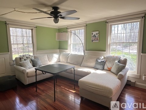 A living room with a white couch and a glass table.