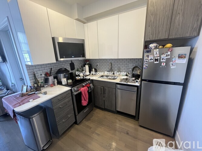 A kitchen with a refrigerator, microwave, and oven.