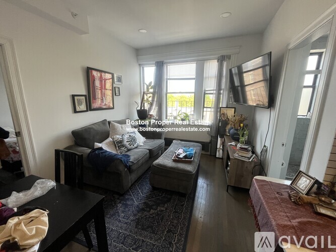 A living room with a black couch and a coffee table.