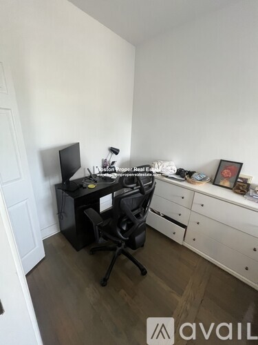 A room with a desk, chair, and computer setup.