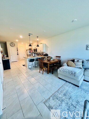 A living room with a white couch and a dining table.