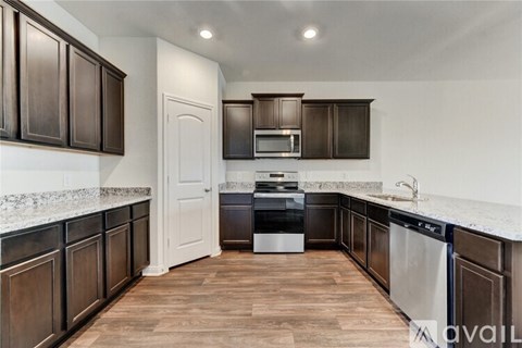 A kitchen with dark wood cabinets and a white door.