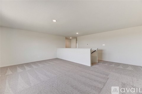 A spacious room with a carpeted floor and a white wall.