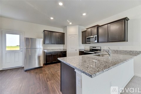 A kitchen with a granite countertop and stainless steel appliances.