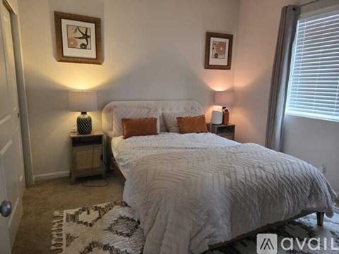 A bedroom with a large bed and two lamps on side tables.