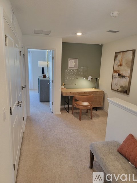 A living room with a grey couch and a wooden chair.