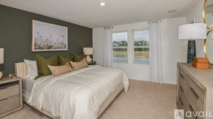A bedroom with a large bed, two nightstands, and a painting on the wall.