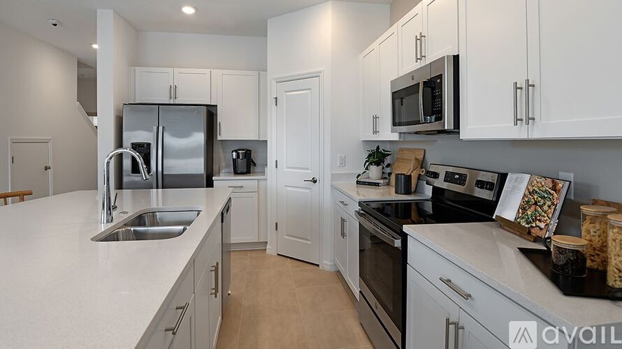 A kitchen with white cabinets and appliances.
