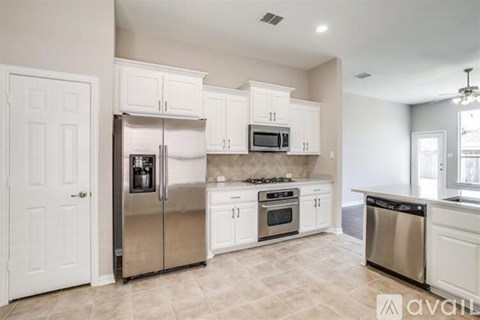 A kitchen with white cabinets and stainless steel appliances.