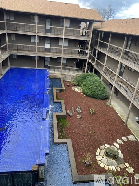 A blue tiled pool in the foreground of a balcony.