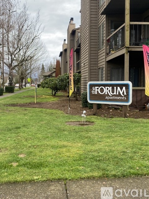 A sign for The Forum Apartments is in the foreground.