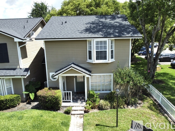A house with a front yard and a white fence.