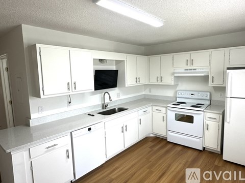 A kitchen with white cabinets and appliances.