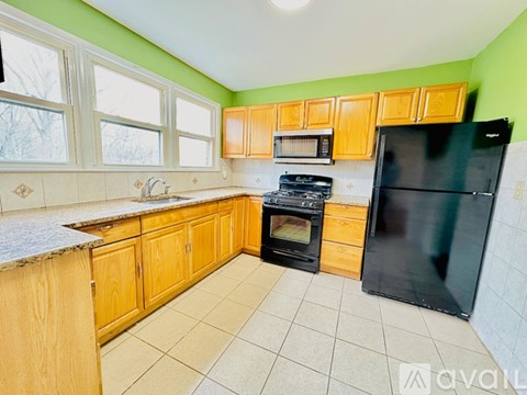A kitchen with wooden cabinets and black appliances.