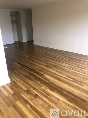 A room with wooden flooring and a white wall.