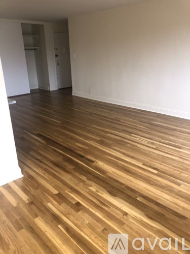 A room with wooden flooring and a white wall.
