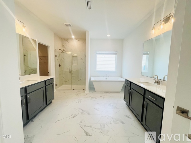 A spacious bathroom with marble flooring and a large mirror.