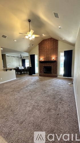 A living room with a fireplace and a ceiling fan.