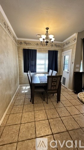 A dining room with a table and chairs.