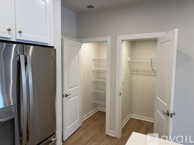 A kitchen with a stainless steel refrigerator and white cabinets.