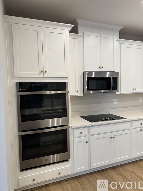 A kitchen with white cabinets and stainless steel appliances.