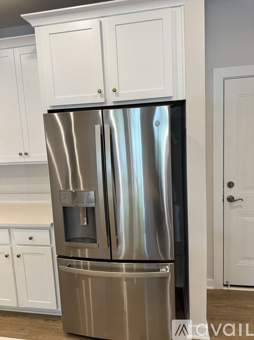 A stainless steel refrigerator with a water and ice dispenser in the middle of the door.