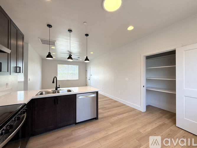 A modern kitchen with dark wood cabinets and a white countertop.