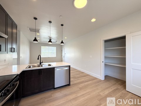 A modern kitchen with dark wood cabinets and a white countertop.