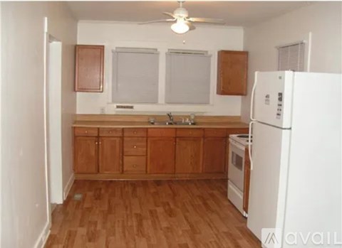 A kitchen with wooden cabinets and a white refrigerator.