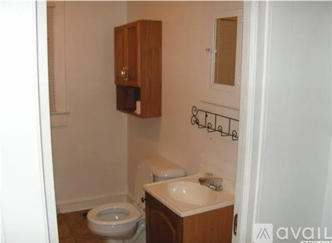 A small bathroom with a toilet, sink, and medicine cabinet.