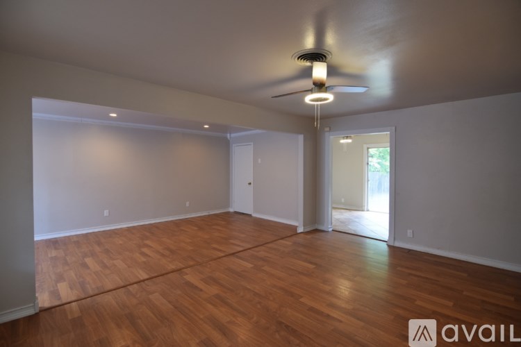 A room with wooden floors and a ceiling fan.