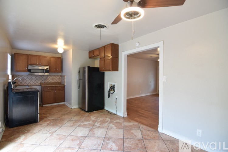 A kitchen with a black fridge and a black dishwasher.