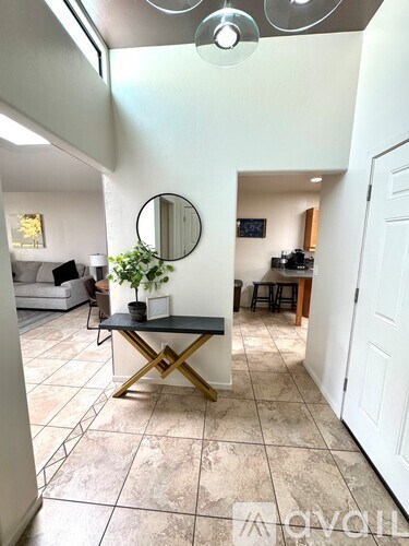 A living room with a black and gold coffee table and a mirror on the wall.