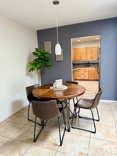 A dining room with a round wooden table and chairs.