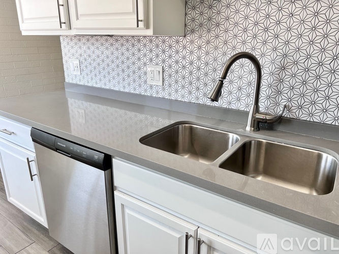 A kitchen with a stainless steel sink and dishwasher.