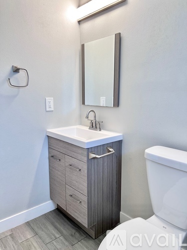 A bathroom with a white sink and a white toilet.