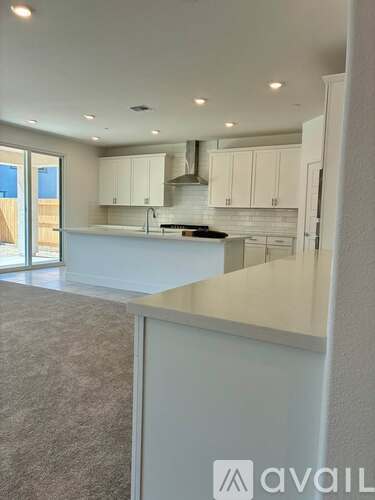 A modern kitchen with white cabinets and a large island.