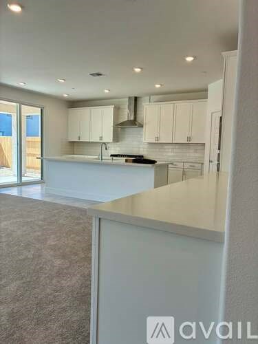 A modern kitchen with white cabinets and a large island.