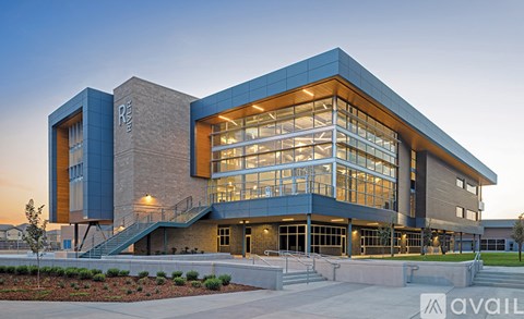 A modern building with a glass facade and a staircase leading to the entrance.
