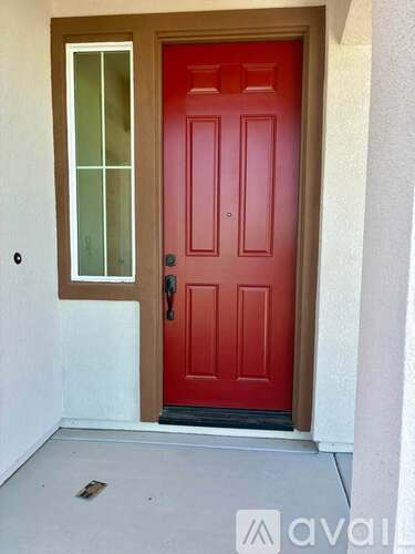 A red door with a glass window on the left and a black handle.