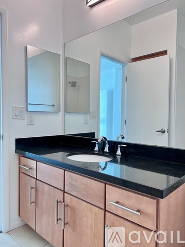 A bathroom with a sink, mirror, and wooden cabinets.
