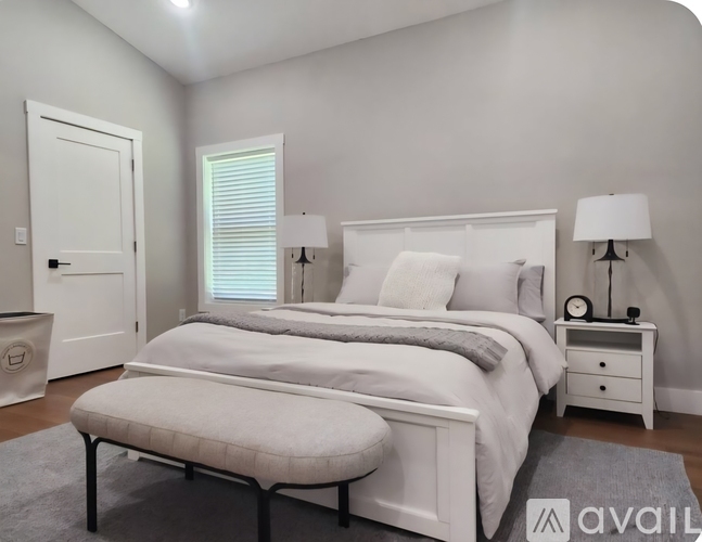 A bedroom with a large bed and a ceiling fan.