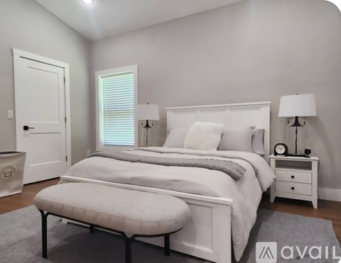A bedroom with a large bed and a ceiling fan.