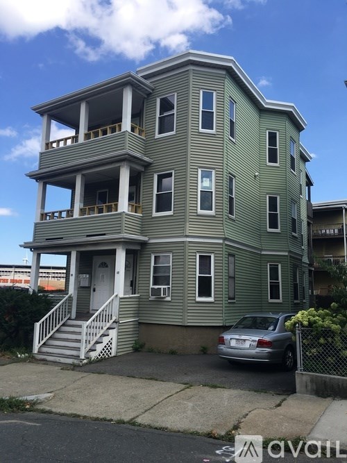 A two-story house with a car parked in front.